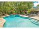 Inviting backyard pool with lounge chairs, umbrella, and mature trees for shade at 20 Stone Gate S, Longwood, FL 32779