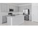 Bright kitchen with stainless steel appliances, gray cabinets, and a spacious island with a sink at 2030 Firethorn Loop, Haines City, FL 33844