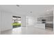Open-concept living space with kitchen, light tile floors, and sliding glass doors to the backyard at 2030 Firethorn Loop, Haines City, FL 33844
