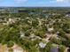 Aerial view of a home with a screened pool and neighborhood, framed by lush trees at 250 Shady Oaks Cir, Lake Mary, FL 32746