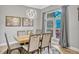 Bright dining room featuring a wooden table, six cushioned chairs, and modern chandelier with large window view at 250 Shady Oaks Cir, Lake Mary, FL 32746