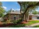 Brick home featuring a well-manicured lawn, garden beds, and a two-car garage at 250 Shady Oaks Cir, Lake Mary, FL 32746
