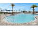 Inviting community pool with sun loungers, umbrellas, and a splash fountain at 2584 Penguin Blvd, Davenport, FL 33837