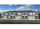 New construction townhomes featuring attached garages, neutral colors, and a well manicured lawn at 2584 Penguin Blvd, Davenport, FL 33837
