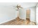 A well-lit bedroom features wood-look floors, a ceiling fan, and a closet with shelving at 2839 Tamarack Trl, Apopka, FL 32703