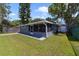 Backyard view of home with screen enclosed patio and access to utility shed and waterway at 30 Sunset Cir, Lake Alfred, FL 33850