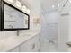 Bright bathroom featuring a white vanity with a marble countertop, a black framed mirror, and updated lighting at 30 Sunset Cir, Lake Alfred, FL 33850