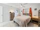 Well-lit bedroom with tile floors, ceiling fan, matching bedside tables and a coordinating wooden dresser at 30 Sunset Cir, Lake Alfred, FL 33850