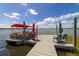 Dock extends into water with a boat and patio furniture, with an open, sunny sky at 30 Sunset Cir, Lake Alfred, FL 33850