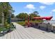 Scenic view of house from dock and canal, featuring a boat, red patio furniture, and an umbrella at 30 Sunset Cir, Lake Alfred, FL 33850