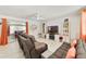 Bright living room with tile floors, a ceiling fan, comfortable seating, and sliding glass doors to the screened porch at 30 Sunset Cir, Lake Alfred, FL 33850