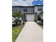 Townhome featuring a paved walkway leading to a garage door and front entrance, with trees planted nearby at 3020 Water Sprite St, Orlando, FL 32808