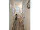 Bright hallway featuring wood-look floors, neutral walls, a decorative mirror and clock, and convenient access to rooms at 3020 Water Sprite St, Orlando, FL 32808