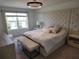 Serene main bedroom featuring tufted headboard, plush bench, and ample natural light at 3020 Water Sprite St, Orlando, FL 32808