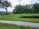Landscaped lawn area with a tranquil pond featuring green space, near a sidewalk, playground and community buildings at 3020 Water Sprite St, Orlando, FL 32808