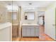 Bathroom features a glass shower, vanity with storage, and tan tiling in this well-lit home at 3225 Hargill Dr, Orlando, FL 32806