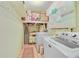 Laundry room with white washer and dryer, storage shelves, and decor at 3225 Hargill Dr, Orlando, FL 32806