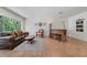 Bright living room featuring a leather sofa, piano, and tile flooring at 3225 Hargill Dr, Orlando, FL 32806