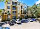 Three story condo with balconies and a parking area with vehicles at 3314 Robert Trent Jones Dr # 308, Orlando, FL 32835