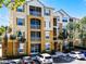Three story condo with balconies, palm trees, and visible parking spaces at 3314 Robert Trent Jones Dr # 308, Orlando, FL 32835