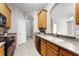 Efficient kitchen featuring tile floors, wood cabinets, and black appliances at 3314 Robert Trent Jones Dr # 308, Orlando, FL 32835