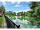 Scenic pond view with lush landscaping, trees, and a reflective water surface under a partly cloudy sky at 3314 Robert Trent Jones Dr # 308, Orlando, FL 32835