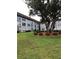 Attractive building exterior with well-maintained landscaping featuring a lush, green lawn and beautiful mature tree at 333 Lake Howard Nw Dr # 302B, Winter Haven, FL 33880