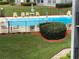 Relaxing pool area with comfortable lounge chairs, landscaping, and privacy fencing at 333 Lake Howard Nw Dr # 302B, Winter Haven, FL 33880