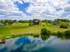 An aerial view showcases a home nestled in a verdant landscape with water views at 36813 Barrington Dr, Eustis, FL 32736