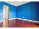Stylish blue bedroom with hardwood floors and doorway to another room at 36813 Barrington Dr, Eustis, FL 32736