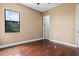 Bright and airy bedroom featuring hardwood flooring, a large window, and neutral paint scheme at 36813 Barrington Dr, Eustis, FL 32736