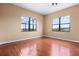 Bright, minimalist bedroom with hardwood floors and backyard view from two windows at 36813 Barrington Dr, Eustis, FL 32736