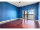 Modern blue bedroom featuring hardwood floors and sliding glass door to the enclosed patio at 36813 Barrington Dr, Eustis, FL 32736