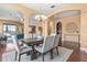 Elegant dining room with a large wooden table, stylish chairs, and arched entryways to other rooms at 36813 Barrington Dr, Eustis, FL 32736