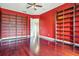 Bright red home office with hardwood floors, ceiling fan, built-in shelving and view to hall at 36813 Barrington Dr, Eustis, FL 32736