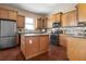 Kitchen featuring wood cabinets, granite counters, island, and stainless steel appliances at 36813 Barrington Dr, Eustis, FL 32736