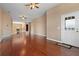 Open living room showcasing hardwood floors, neutral walls, ceiling fans, and front door at 36813 Barrington Dr, Eustis, FL 32736