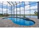 Beautiful pool and spa in a screened enclosure, with lake view and stone pavers at 36813 Barrington Dr, Eustis, FL 32736