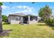 View of the backyard showcasing lush green lawn and patio, providing an ideal space for outdoor relaxation and recreation at 3714 Marigot Way, Clermont, FL 34711