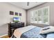 Comfortable bedroom featuring a window with plantation shutters, wood floors, and a ceiling fan at 3714 Marigot Way, Clermont, FL 34711