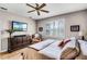 Comfortable bedroom featuring a ceiling fan, wood floors, and window with plantation shutters at 3714 Marigot Way, Clermont, FL 34711