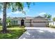 Lovely home boasts a three-car garage and beautiful landscaping enhancing its curb appeal on a sunny day at 3714 Marigot Way, Clermont, FL 34711