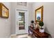Welcoming foyer featuring a decorative table, mirror, and view of the outdoors through a glass-paneled front door at 3714 Marigot Way, Clermont, FL 34711