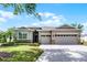 Charming single-story home with a three-car garage, stone accents, and manicured landscaping in a serene setting at 3714 Marigot Way, Clermont, FL 34711