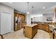 Open-concept kitchen boasts granite countertops, ample cabinetry, stainless steel appliances, and a central island at 3714 Marigot Way, Clermont, FL 34711
