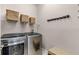 Well-lit laundry room equipped with modern washer and dryer units, shelving, and a seating bench at 3714 Marigot Way, Clermont, FL 34711