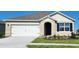 Charming single-Gathering home featuring a two-car garage, manicured lawn and colorful flower beds at 3735 Bluethread Way, Poinciana, FL 34759
