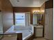 Bathroom featuring a sunken tub with white tile surround and a large window at 4526 Oakton Dr, Orlando, FL 32818