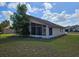 View of the home's exterior featuring a screened-in porch and well-maintained lawn at 4526 Oakton Dr, Orlando, FL 32818