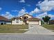 Charming single-story home featuring a two-car garage and well-maintained front lawn under a bright, cloudy sky at 4526 Oakton Dr, Orlando, FL 32818